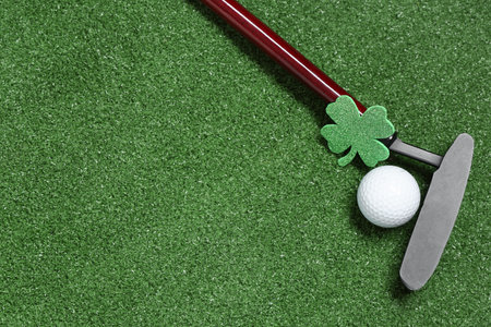 Golf club, ball and clover on green grass background. St. Patrick's Day celebrationの写真素材