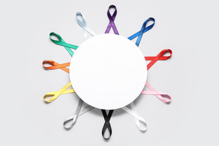 Blank card with different colorful ribbons on gray background. Cancer awareness conceptの写真素材