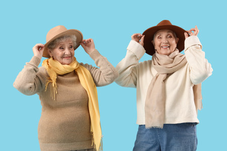 Senior female friends in stylish clothes on blue backgroundの写真素材