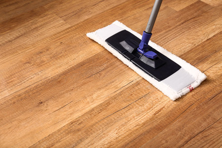 Cleaning of wooden laminate floor with mop, closeupの写真素材