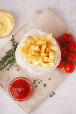 Glass with tasty French fries and sauces on white backgroundの写真素材