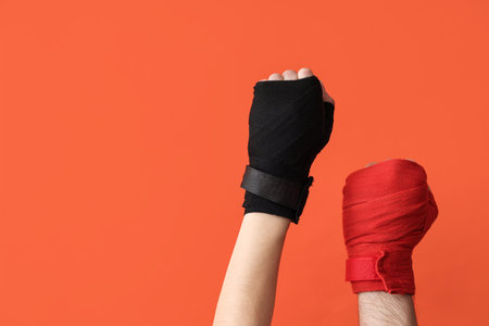 Female hands in boxing bandages on orange backgroundの写真素材