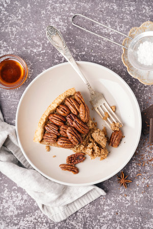 Plate with piece of tasty pecan pie on gray backgroundの写真素材