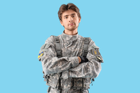 Young Ukrainian soldier on blue backgroundの写真素材