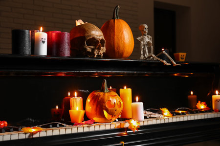 Grand piano with burning candles and Halloween decor in dark roomの写真素材