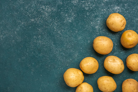 Fresh raw potatoes on blue backgroundの写真素材