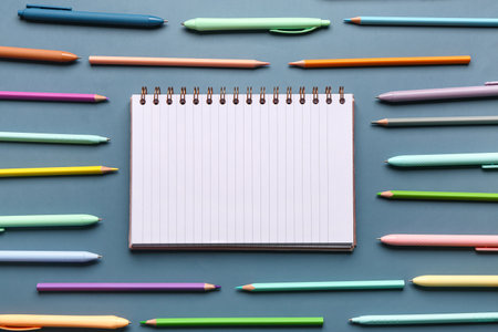 Notebook with pens and pencils on blue backgroundの写真素材