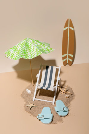 Creative summer composition with mini umbrella, deckchair and beach accessories on color background