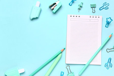 Notebook with different stationery supplies on blue backgroundの写真素材