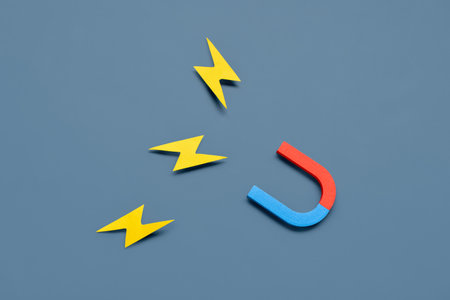 Horseshoe shaped magnets with paper lightnings on blue backgroundの写真素材