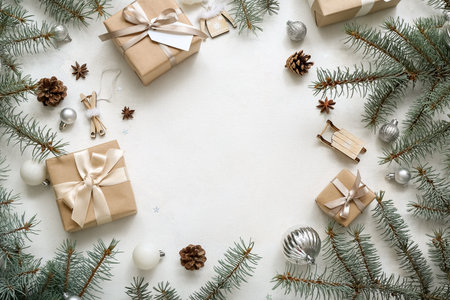 Frame made of Christmas tree branches with balls and gift boxes on white backgroundの写真素材
