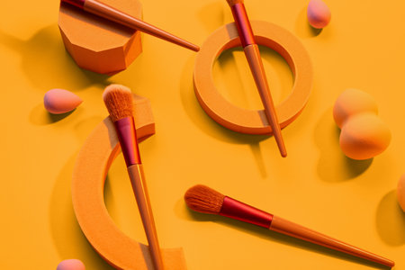 Decorative podiums with makeup brushes and sponges on yellow backgroundの写真素材
