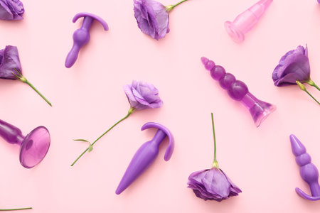 Purple anal plugs from sex shop and beautiful eustoma flowers on pink backgroundの写真素材
