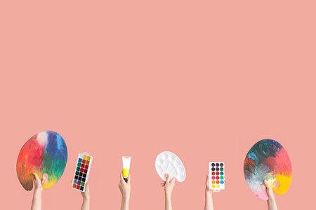 Female hands with artist's supplies on pink backgroundの写真素材