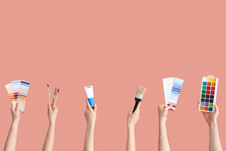 Female hands with artist's supplies on pink backgroundの写真素材