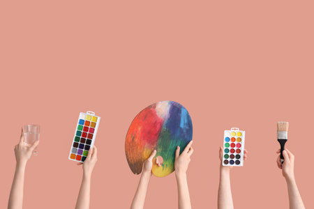 Female hands with artist's supplies on pink backgroundの写真素材