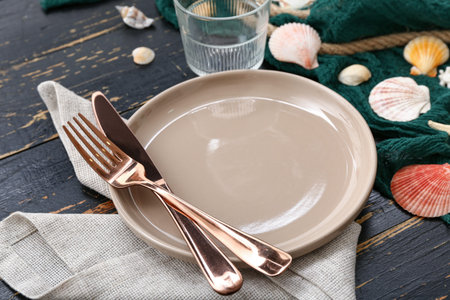 Beautiful table setting with marine decor on black wooden background