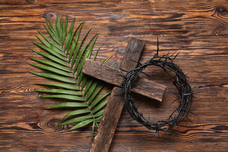 Crown of thorns with cross and palm leaf on wooden background. Good Friday conceptの写真素材