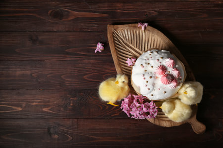 Easter cake, hyacinth, chicks and wooden tray on table, closeup