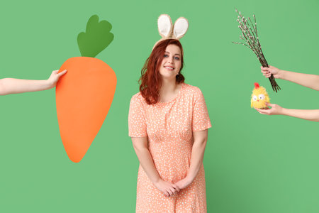 Beautiful young woman in bunny ears and hands with pussy willow branches, paper carrot and toy chick...