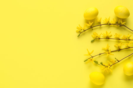 Composition with blossoming branches and Easter eggs on yellow backgroundの写真素材