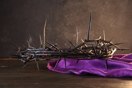 Crown of thorns with purple cloth on wooden table against black grunge background. Good Friday conceptの写真素材