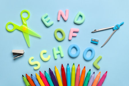 Text END OF SCHOOL, scissors and colorful felt-tip pens on blue background. Top viewの写真素材