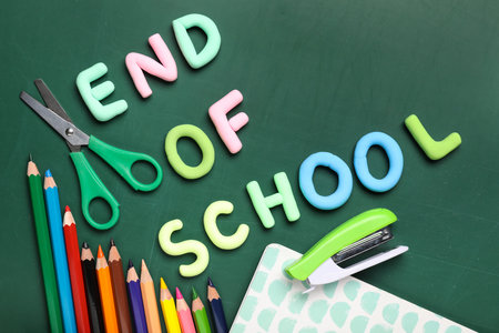 Text END OF SCHOOL, pencils and scissors on green background. Top viewの写真素材