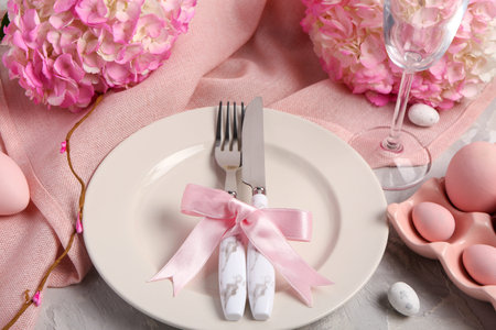 Beautiful table setting with Easter eggs and hydrangea on grunge background