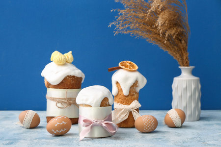 Easter cakes and eggs on blue table