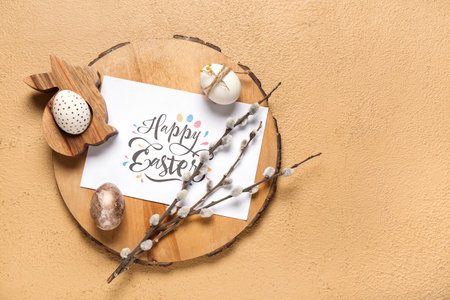 Greeting card with text HAPPY EASTER, eggs and willow branches on brown backgroundの写真素材