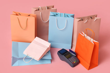 Shopping bags and payment terminal on pink backgroundの写真素材