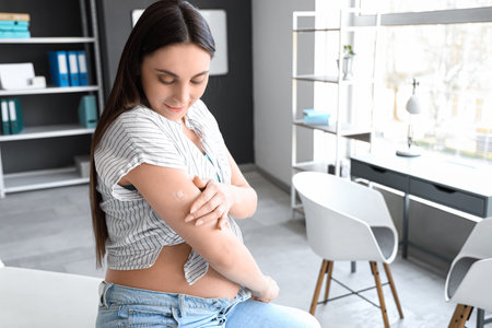 Young pregnant woman with medical patch after vaccination in clinicの写真素材
