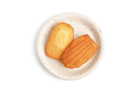 Saucer with tasty Madeleine cookies on white backgroundの写真素材