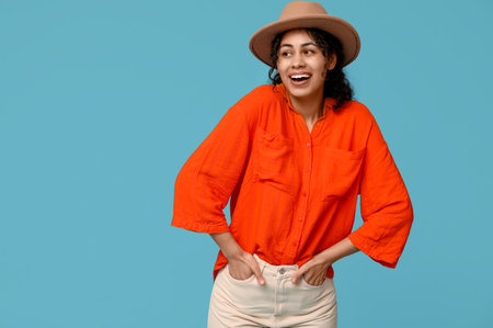 Stylish African-American woman in hat on blue backgroundの写真素材