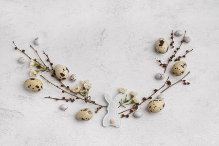 Branches, eggs and fabric bunny on light backgroundの写真素材