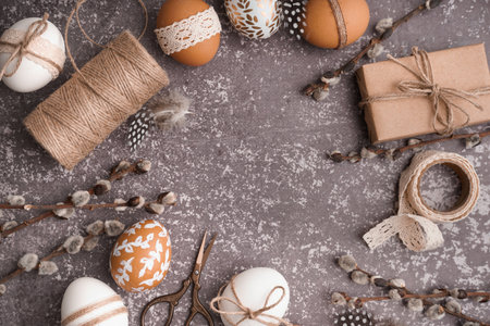 Composition with Easter eggs, willow branches and gift box on gray backgroundの写真素材
