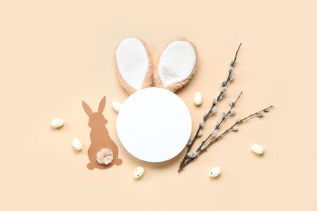Blank card with bunny ears, Easter eggs and willow branches on beige backgroundの写真素材