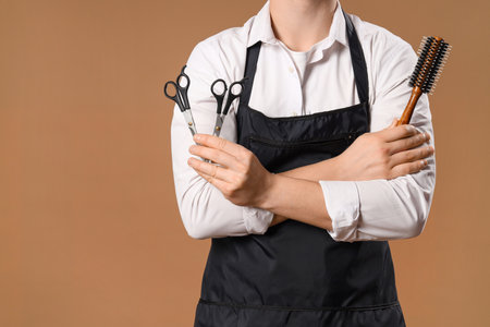 Young barber with scissors and brush on brown background, closeupの写真素材