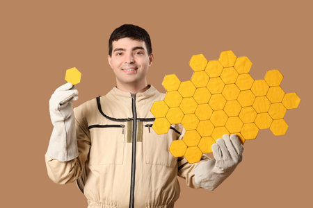 Male beekeeper with paper honeycombs on brown backgroundの写真素材