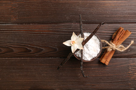 Bowl of vanilla powder, sticks and cinnamon on dark wooden backgroundの写真素材