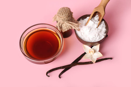Bowls with vanilla extract, powder and sticks on pink backgroundの写真素材