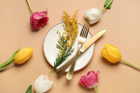 Beautiful table setting with mimosa flowers and tulips on brown backgroundの写真素材