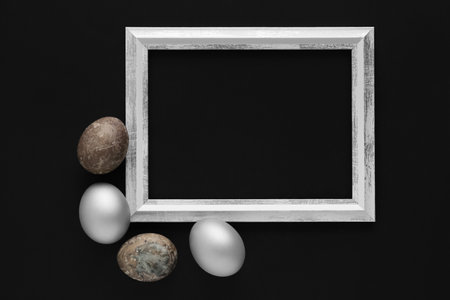Beautiful composition with frame and Easter eggs on black backgroundの写真素材