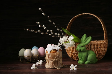 Easter cake, eggs, bunny, basket, hyacinth and willow branches on wooden background