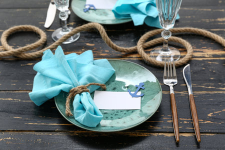 Beautiful table setting with marine decor on black wooden backgroundの写真素材