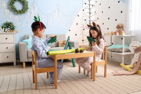 Cute little children creating Christmas decor at homeの写真素材