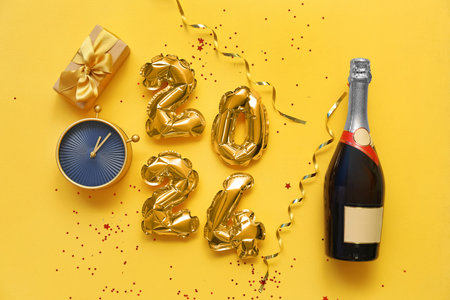 Figure 2024 made of balloons with Christmas decorations, alarm clock and champagne bottle on orange...