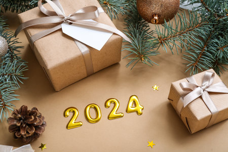 Figure 2024 with Christmas tree branches and gift boxes on brown backgroundの写真素材