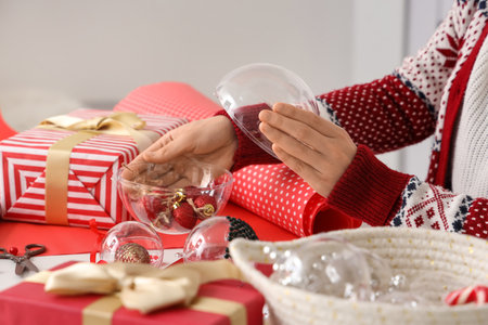 Woman decorating Christmas balls on tableの写真素材